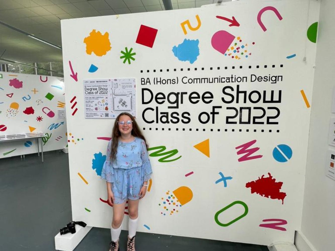Kitty Donovan stands in front of Degree Show signage