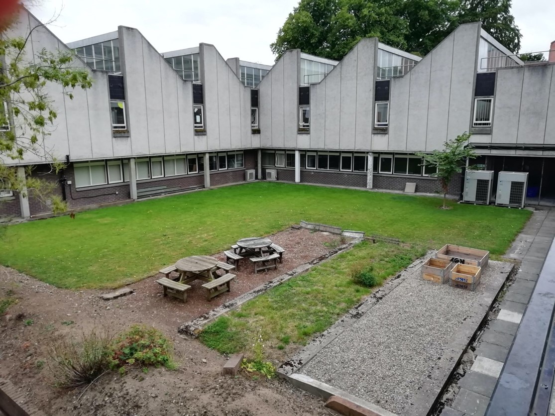 Wide shot of garden with benches, planters and grass at RGU Campus