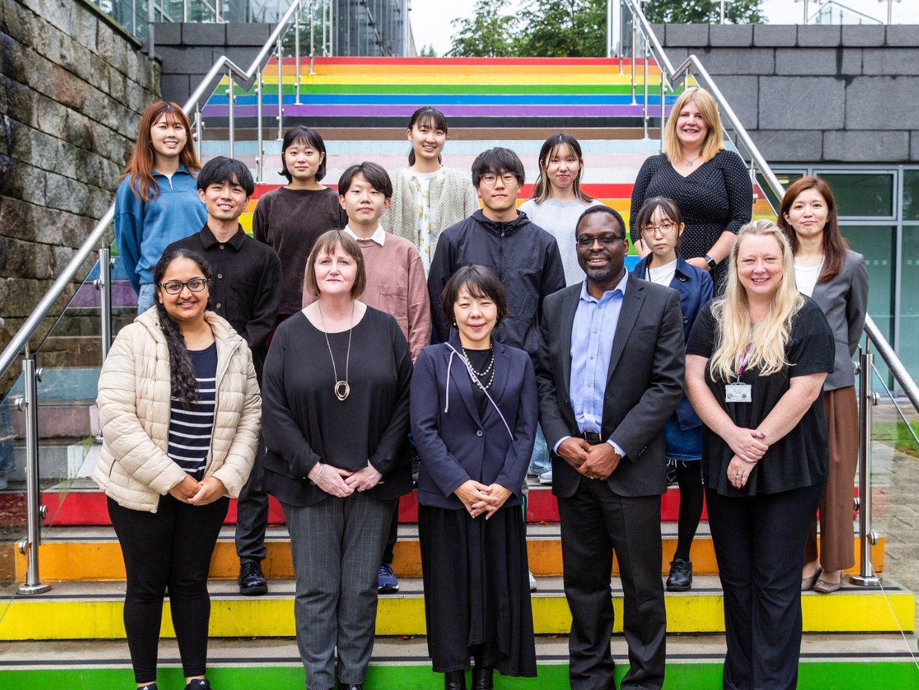 Japanese students and RGU representatives stand at rainbow staircase on RGU Campus