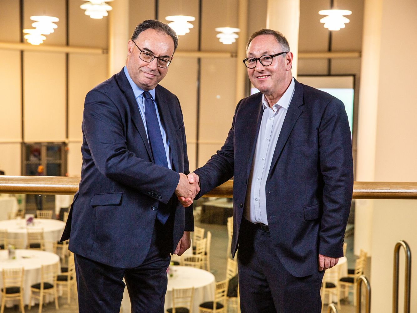 Andrew Bailey and Paul de Leeuw shake hands.