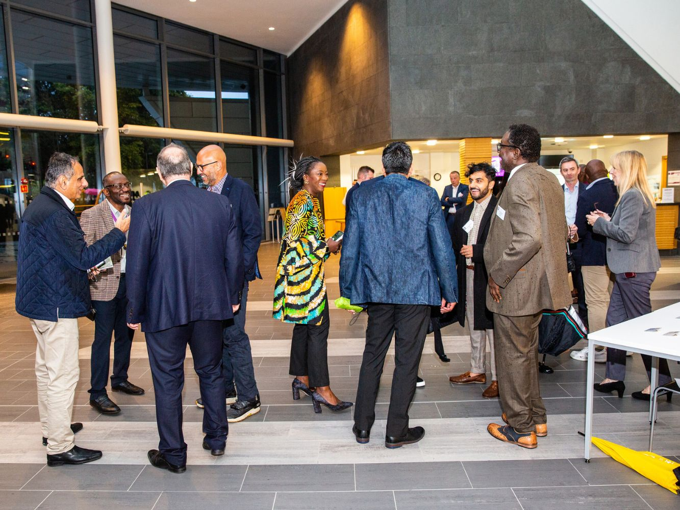 Attendees arrive and welcome each other in the concourse.