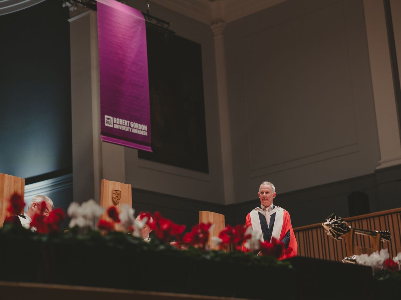 Mark Logan standing on stage at the Music Hall
