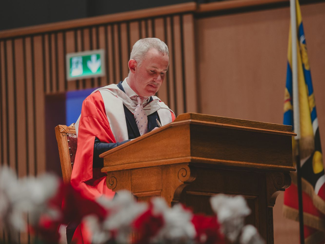 Mark sitting and signing the honorary degree book