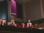 Mark Logan standing on stage at the Music Hall