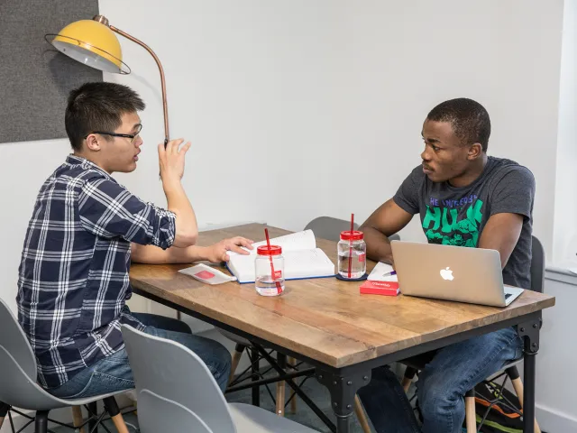 two students chatting at a table