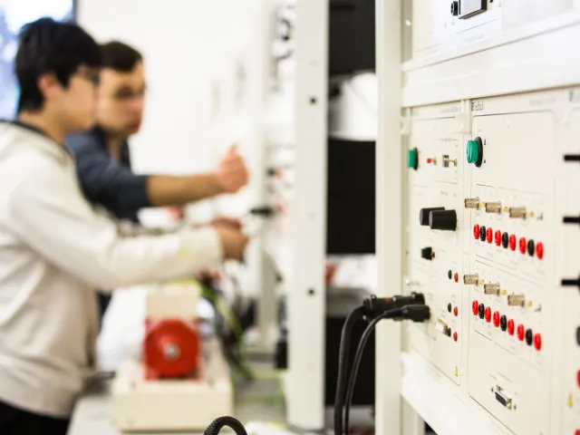 two people using electrical control panel