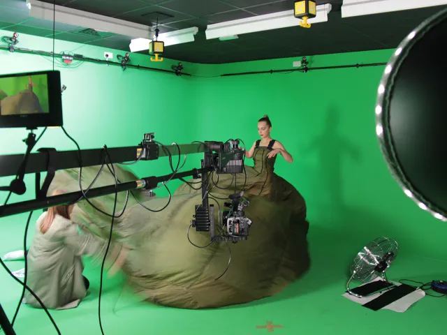 a model in a green room wearing an extravagant dress
