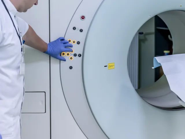 health professional pressing buttons on an MRI machine