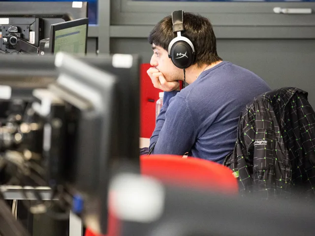 student wearing headset looking at computer screen