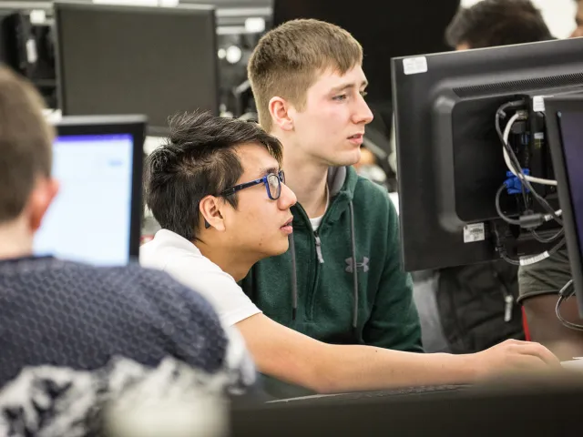 students looking at monitor in computer lab