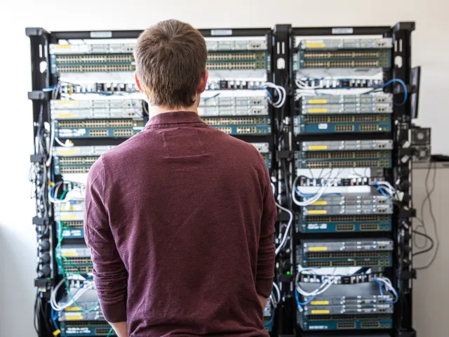 man looking at servers in Cisco Networking Lab