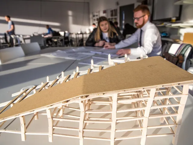 people chatting next to structural model