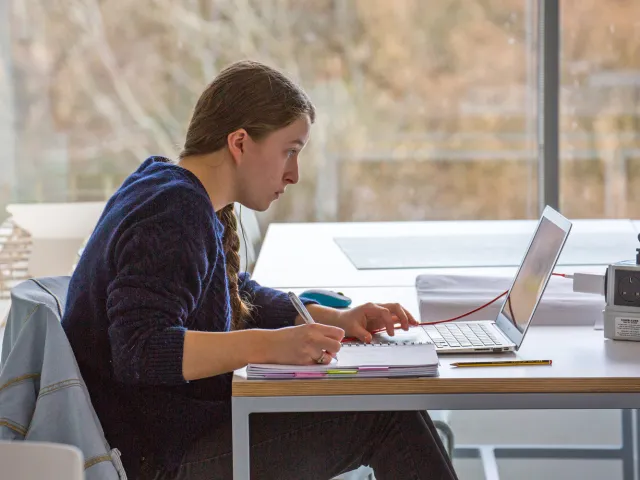 student on laptop in classroom