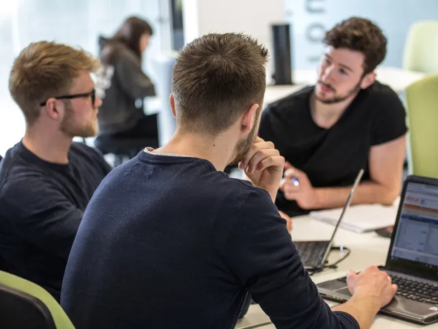 students chatting next to their laptops