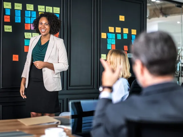 people in a meeting with sticky notes on the wall
