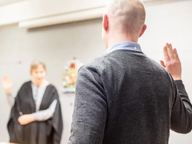 man holding his hand up to swear in