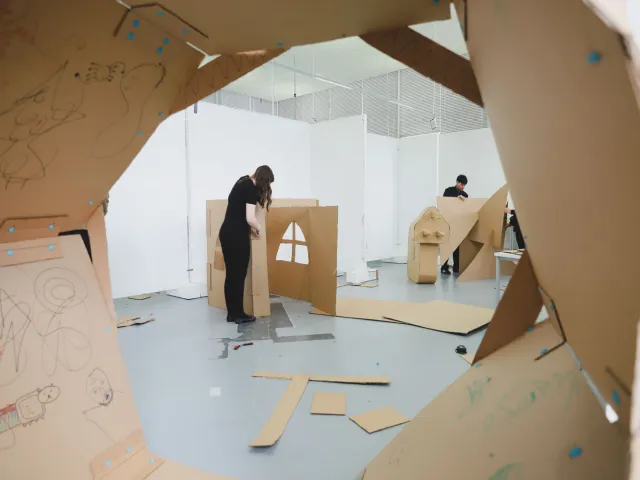 students working on a collaborative cardboard art piece