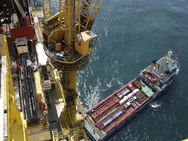 view of a boat from on board an oil platform