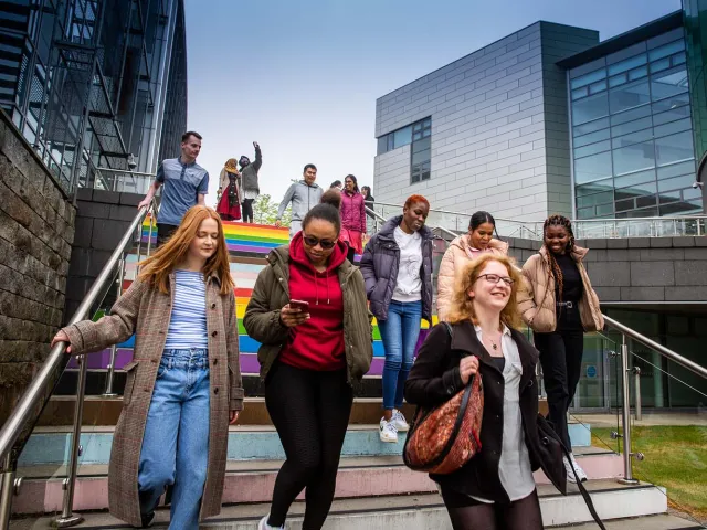 students walking down the rainbow steps on campus
