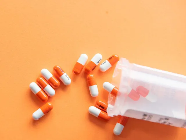 orange pills spilling out of a container