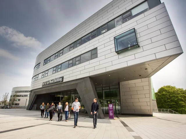 students walking out of the sir ian wood building