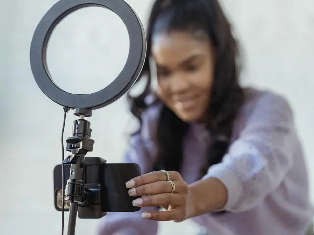 Person using a mobile phone and ring light