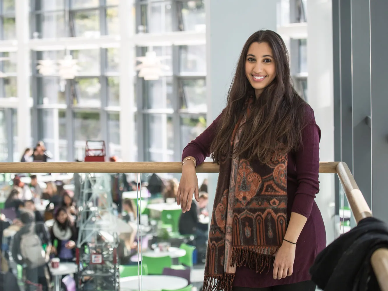 student standing on steps at RGU campus smiling