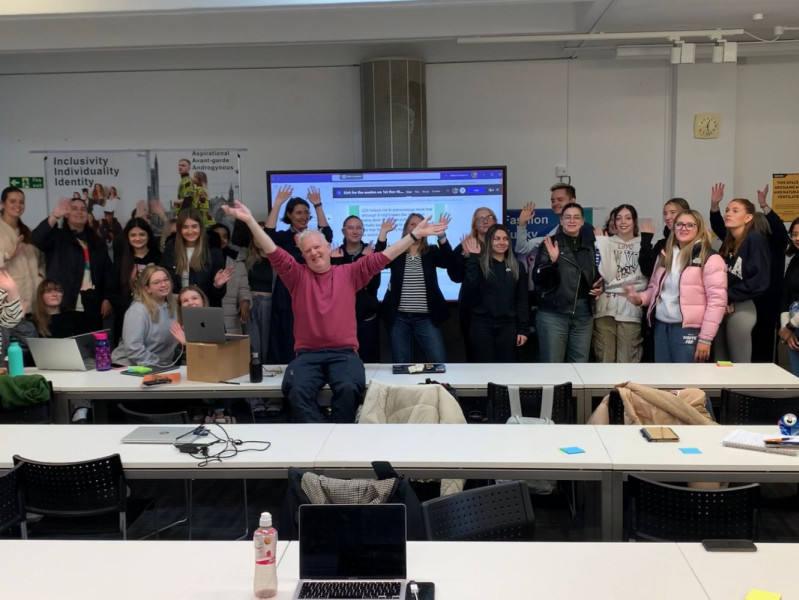 Students and staff members waving at the camera