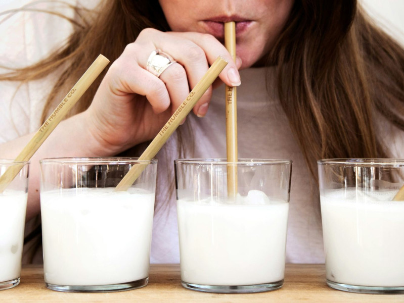 Person drinking out of a bamboo straw