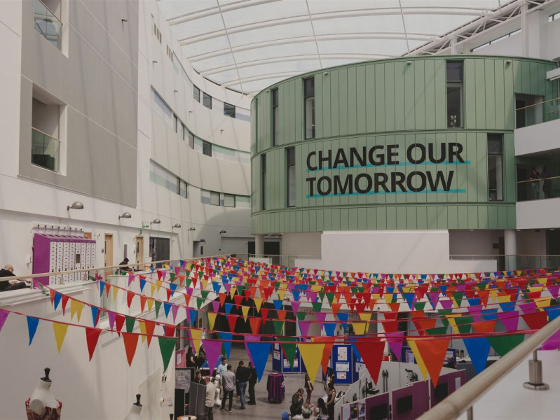 Inside the Sir Ian Wood Building with rows of colourful small flags hanging from the ceiling