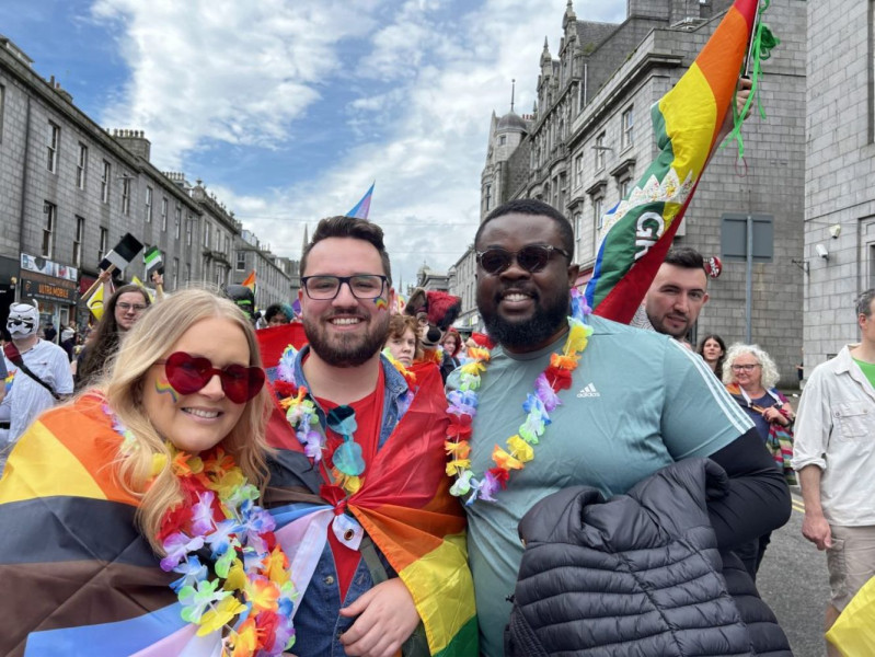 Daniel Massie at the 2023 Grampian Pride Parade with a staff member at his right and left.