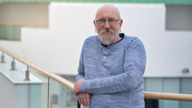 Phil Chaplain leaning on a balustrade in the Sir Ian Wood Building