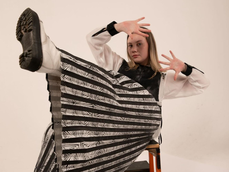 Image shows model sitting on a chair with leg up showing fashion on sale at Gray's pop up shop.