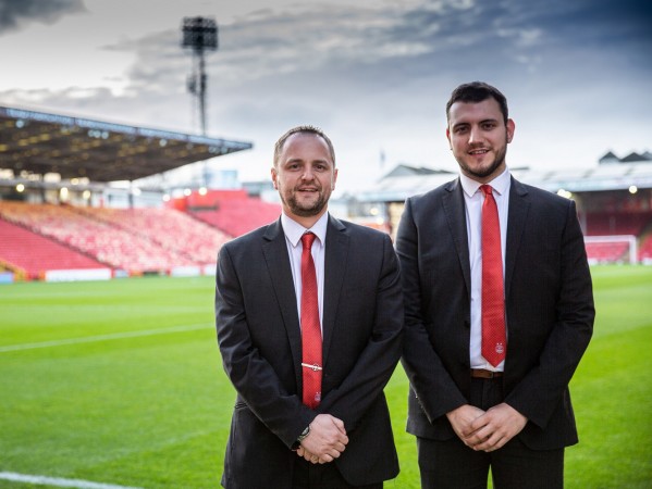 Two Graduate Apprentices in a football stadium