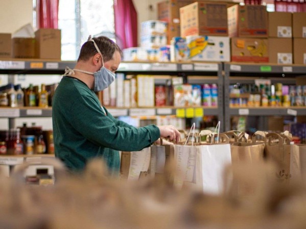 Man wearing face mask organising food donation bags Man wearing face mask organising food donation bags