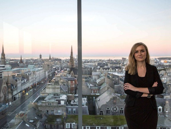 woman next to a window with a view over Aberdeen