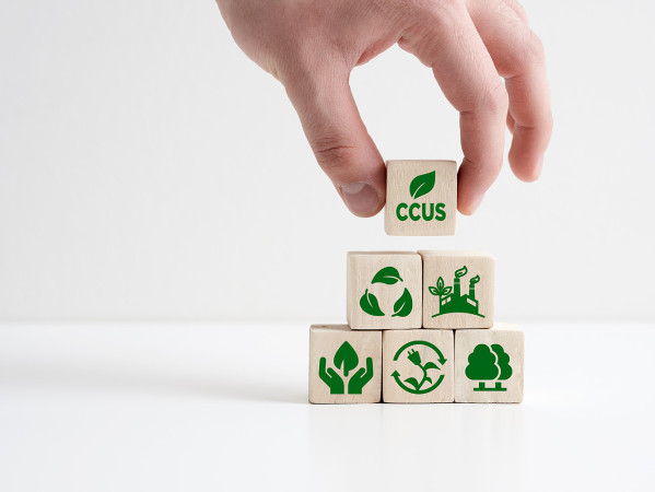 a hand holding building blocks with sustainability icons