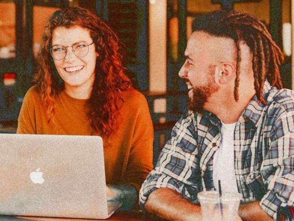 Image shows two people chatting with a laptop - Source: Unsplash