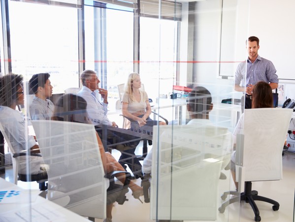 person presenting to a group of people at a desk