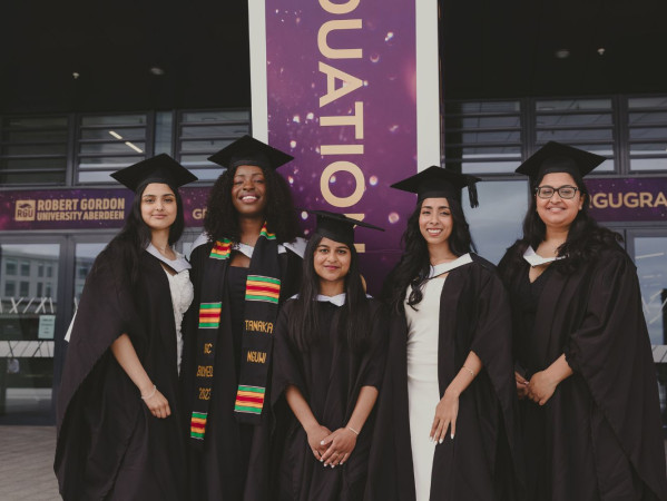 RGU graduates standing smiling outside P&J Live, Aberdeen