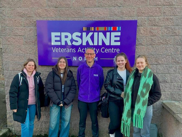 people standing in front of a sign that says erskine