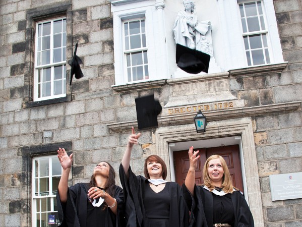 Graduates in gowns throwing their caps in the air