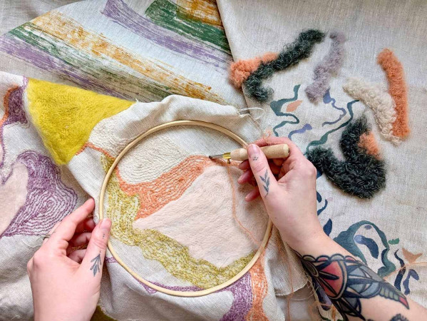 person hand sewing embroidery