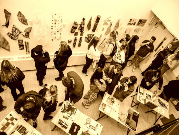 Sepia toned image of lots of people in a gallery