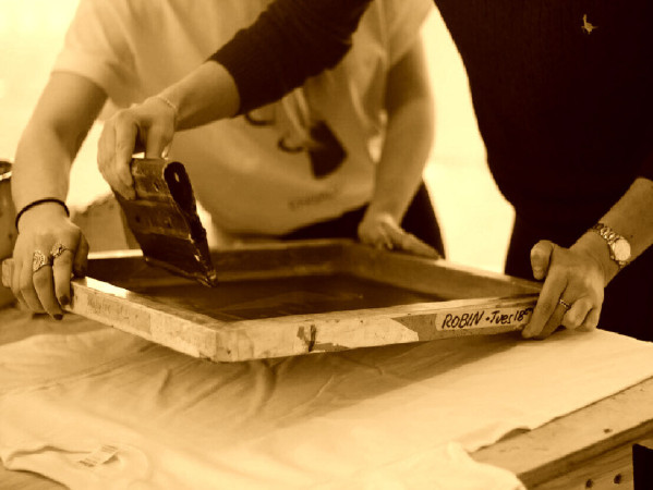 Sepia toned image of people screenprinting