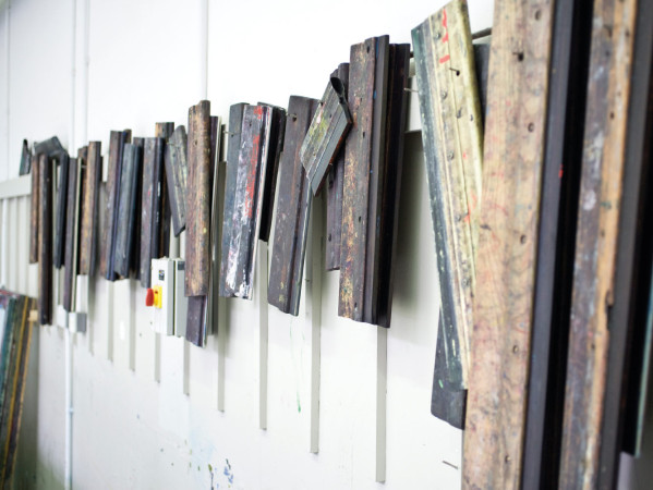 printmaking squeegees hanging on a wall