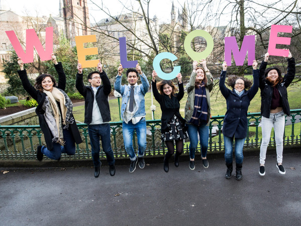 International Students holding up letters spelling Welcome