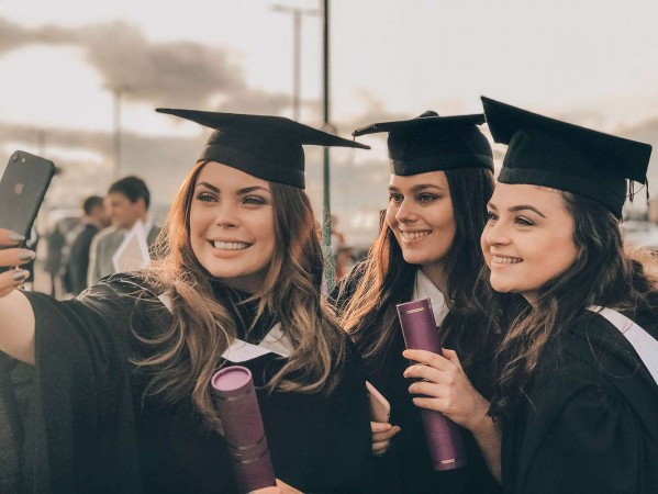 girls in graduation outfits taking a selfie