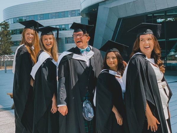 Graduates in gowns outside the Sir Ian Wood Building on campus