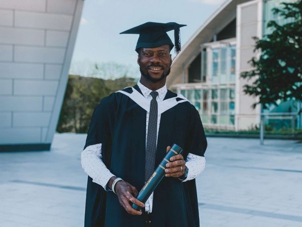 Graduate with gown and scroll